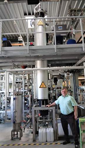 Ingenieur Benjamin Pacan erklärt die Methanisierungs-Versuchsanlage im PFI. Untersucht wird, welche Bedingungen für spezielle Archäen („Urbakterien") optimal sind. Foto. W. G. Stähle.