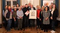Bei der Verleihung des Ehrenamtspreises an Seniorenbüro-Ehrenamtsbörse LD. Beigeordnete Lena Dürphold (rechts), Laudator Hans-Dieter Schlimmer (hintere Reihe, 6. v. l.), davor die Vereinsvorsitzenden Uli Müller-Weissner (mit Bild) und Ulrich Teichmann (mit Spendenscheck), die städtische Ehrenamtsbeauftragte Angelika Kemmler (vordere Reihe, 4. v. r.) sowie einige Mitglieder des Vereins. Foto. Stadt. LD. Frei. 