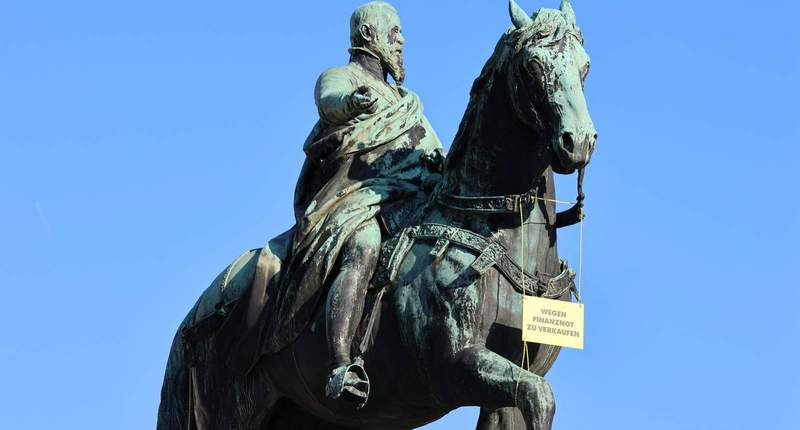 Mit einer symbolischen Verkaufsanzeige für den „Reiter“ auf dem Rathausplatz hatte sich die Stadt LD im Sommer am Aktionstag „Kommunen am Limit“ beteiligt. Mit dem Nachtragshaushaltsentwurf wird jetzt deutlich. Die Lage ist sehr ernst. Foto. Stadt. LD. Frei.