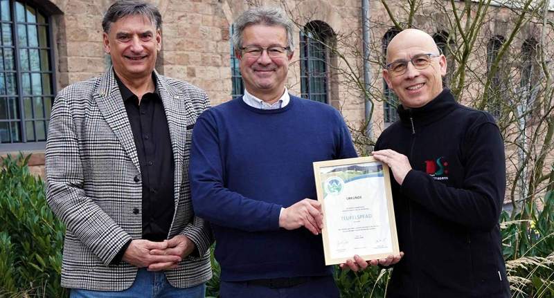 Auf dem „Teufelspfad" wird weiterhin auf Premium-Niveau gewandert. Darüber freuen sich Manuel Andrack (Mitte) vom Deutschen Wanderinstitut, der die Urkunde an Stadtmarketing-Chef Rolf Schlicher (links) und Mitarbeiter Götz Krämer übergeben hat, der für das Thema Wandern zuständig ist. Foto. Stadt. PS. Sabine Reiser.