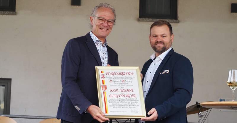Axel Wassyl (links) bekommt von Ortsbürgermeister Simon Wingerter die Ehrenbürgerurkunde überreicht. Foto. Veranstalter.