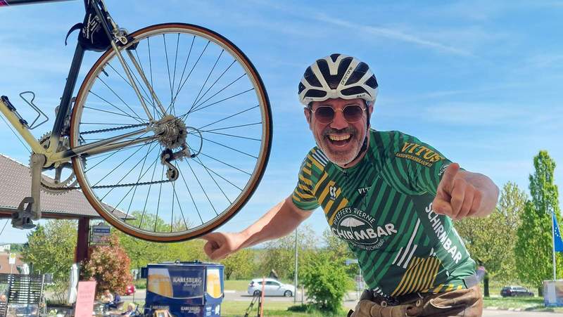 Freut sich riesig auf das morgige Radrennen mit seinem Schirmbar-Vitus-Team. Bernd Pfeffer ist seit vergangenem Jahr Radstall-Sponsor. Anlässlich des großen Rad-Events hat er ein Rennrad in seiner Schirmbar am Weintor aufgehängt. Foto. rw.