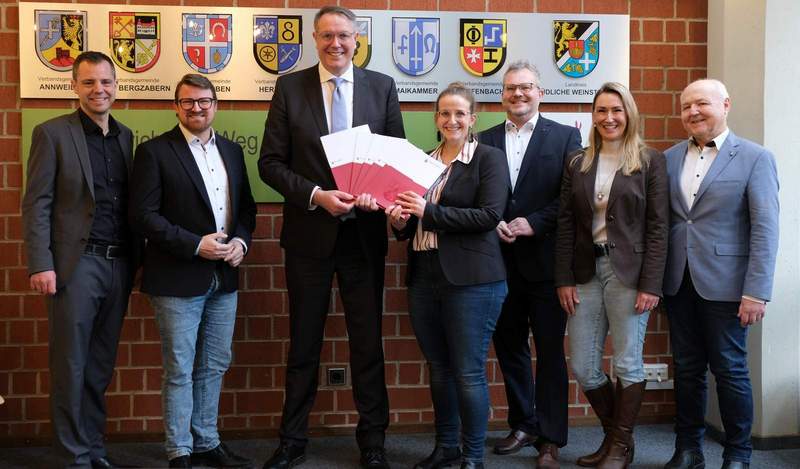 Von links. Florian Maier und Sven Koch, beide Mitglieder des rheinland-pfälzischen Landtags, MP Alexander Schweitzer, SÜW-Gigabitbeauftragte Karolin Söltner, Büroleiter der Kreisverwaltung Sebastian Renner, Referatsleiterin Digitalisierung Manuela Kleinbauer und Albert Schädler, Breitbandberater, bei der Bescheidübergabe. Foto. KV. SÜW. Frei. 