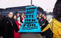 Aktion Aufstehen für Demokratie (29): Bischof Wiesemann und Kirchenpräsidentin Wüst (beide hinten Mitte) zusammen mit Vertreterinnen und Vertretern von Bistum, Landeskirche, der koptisch-orthodoxen und der rumänisch-orthodoxen Gemeinde beim Hissen der Flagge. Foto. Klaus Landry. Frei.