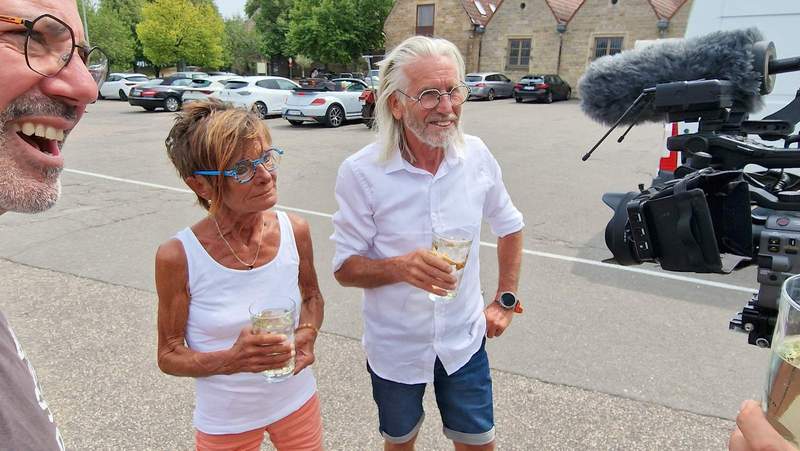Willkommensgruß vom Schirmbar-Wirt, em Pfeffers Bernd (links). Ään Schoppe Riesling-Schorle. Auch war das Fernsehen da. Foto. rw. 