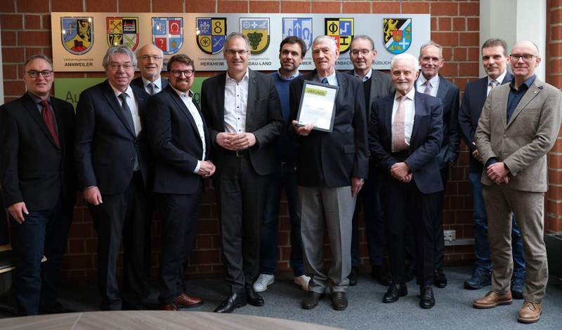 Von Gratulanten umgeben. Landrat Dietmar Seefeldt (Fünfter von links) überreichte Dr. Hans-Werner Mollenhauer (Siebter von links) neben der Goldenen Kreiswappennadel eine Urkunde. Foto. KV. SÜW. Frei. 