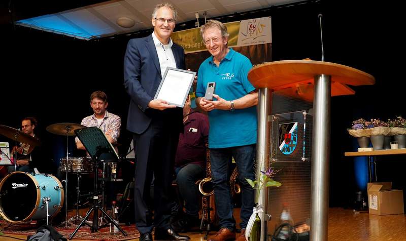 Peter Kusenbach, rechts, unter anderem Leiter des Chors „Herztöne", der bei „Deutschland singt und klingt" vertreten war, bekam von Landrat Dietmar Seefeldt die Goldene Wappennadel des Landkreises SÜW überreicht. Foto. Dieter Hammann. Pressefrei. 