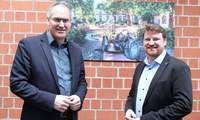 Landrat Dietmar Seefeldt (links) und Sven Koch im Jahr 2024 im Kreishaus SÜW, vor einem Foto des Herxheimer Dorfbrunnens. Archivfoto. KV. SÜW. Frei. 