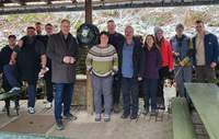 Landrat Dietmar Seefeldt (Fünfter von links) mit Engagierten des Wanderclubs Nello am AED-Gerät, das unter einem Unterstand an der Nello-Hütte befestigt und dadurch leicht zugänglich ist. Foto. KV. SÜW. Frei.