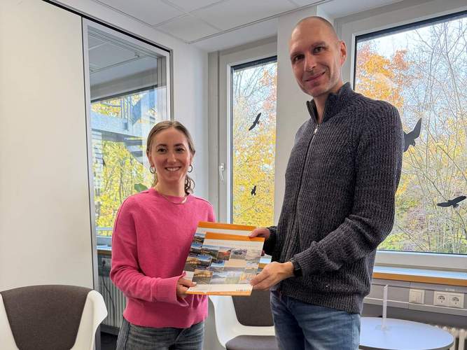ESW-Mitarbeiter Arne Kruse und seine Kollegin Johanna Schiffmann präsentieren den ESW-Familienkalender 2026. Foto. ESW. Pressefrei. 