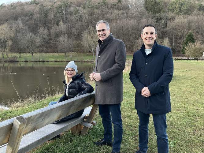 Am Silzer See laden vier neue Sitzbänke zum Verweilen ein, hier Ortsbürgermeisterin Elke Mandery, Landrat Dietmar Seefeldt und Christian Burkhart, Bürgermeister der VG Annweiler. Foto: Ortsgemeinde Silz. Frei.