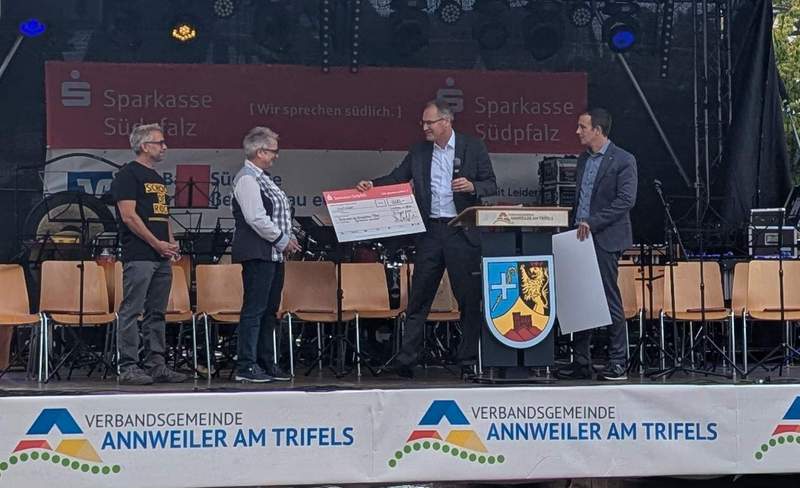 Zwei auf einen Streich: In Annweiler überreichte Landrat Dietmar Seefeldt (Zweiter von rechts) mit VG-Bürgermeister Christian Burkhart (rechts) einen Scheck an die Teamkapitänin beziehungsweise den -kapitän des Evangelischen Trifels-Gymnasiums und des Staufer-Schulzentrums. Foto. KV. SÜW. Frei.