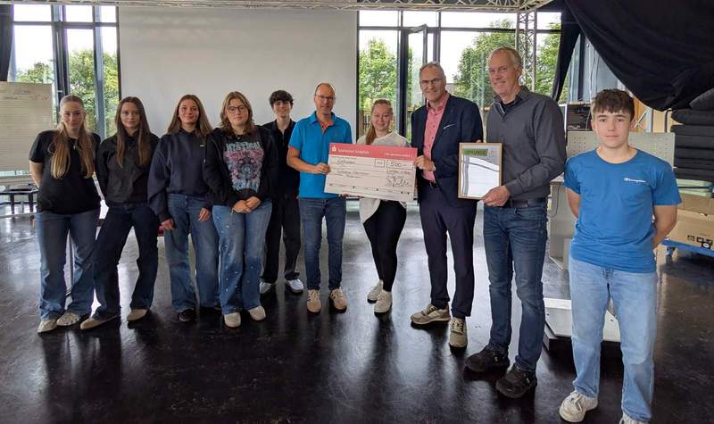 Landrat Dietmar Seefeldt (Dritter von rechts) und SÜW-Klimaschutzmanagerin Agnes Bartmus (Vierte von rechts) gratulieren dem Gewinner des Schulradelns, dem Gymnasium Edenkoben, mit einem Scheck. Foto. Gymnasium Edenkoben. Pressefrei. 