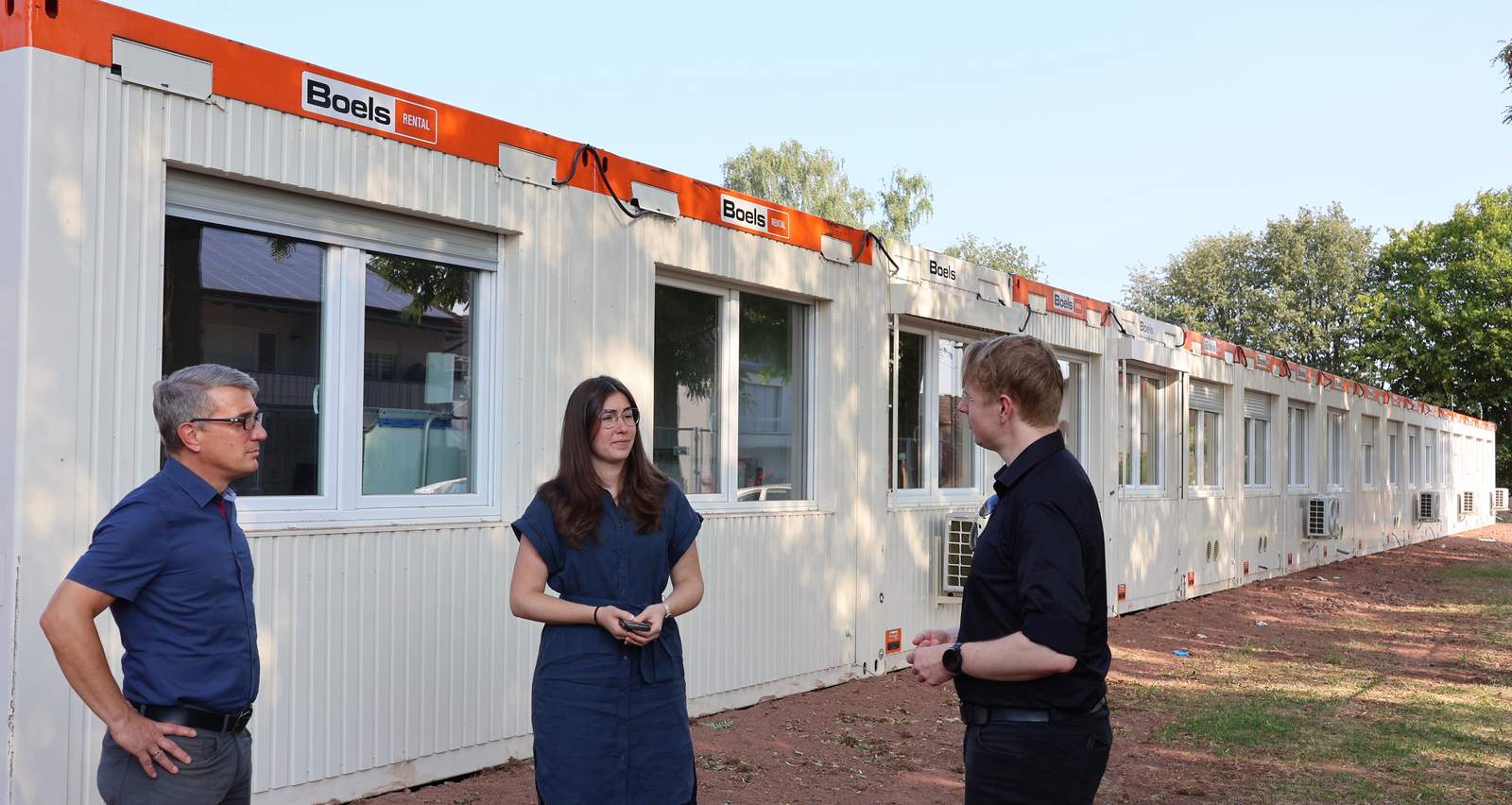 Lukas Hartmann, Lena Dürphold und Timo Pust (v.r.n.l.) beim Vor-Ort-Termin in Nußdorf. Hier hat die Stadt moderne Schulcontainer aufgestellt. Foto. Stadt. LD. Frei. 