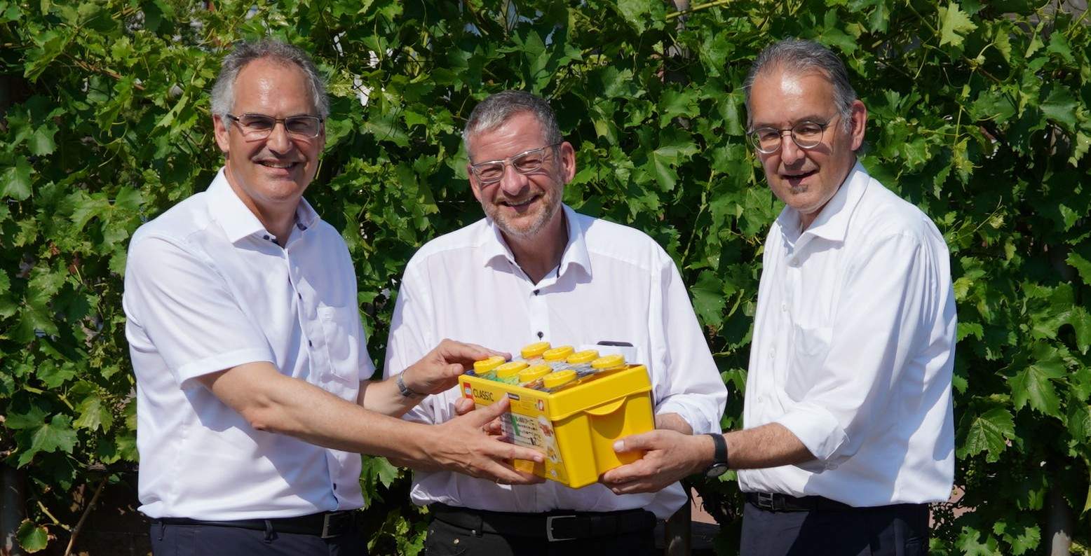 Landrat Dietmar Seefeldt (links) und Erster Kreisbeigeordneter Georg Kern (rechts) gratulierten Ortsbürgermeister Matthias Ackermann zur Erweiterung der Kita Birkenhördt und übergaben ihm ein Geschenk für die Kita. Foto. KV. SÜW. Frei. 