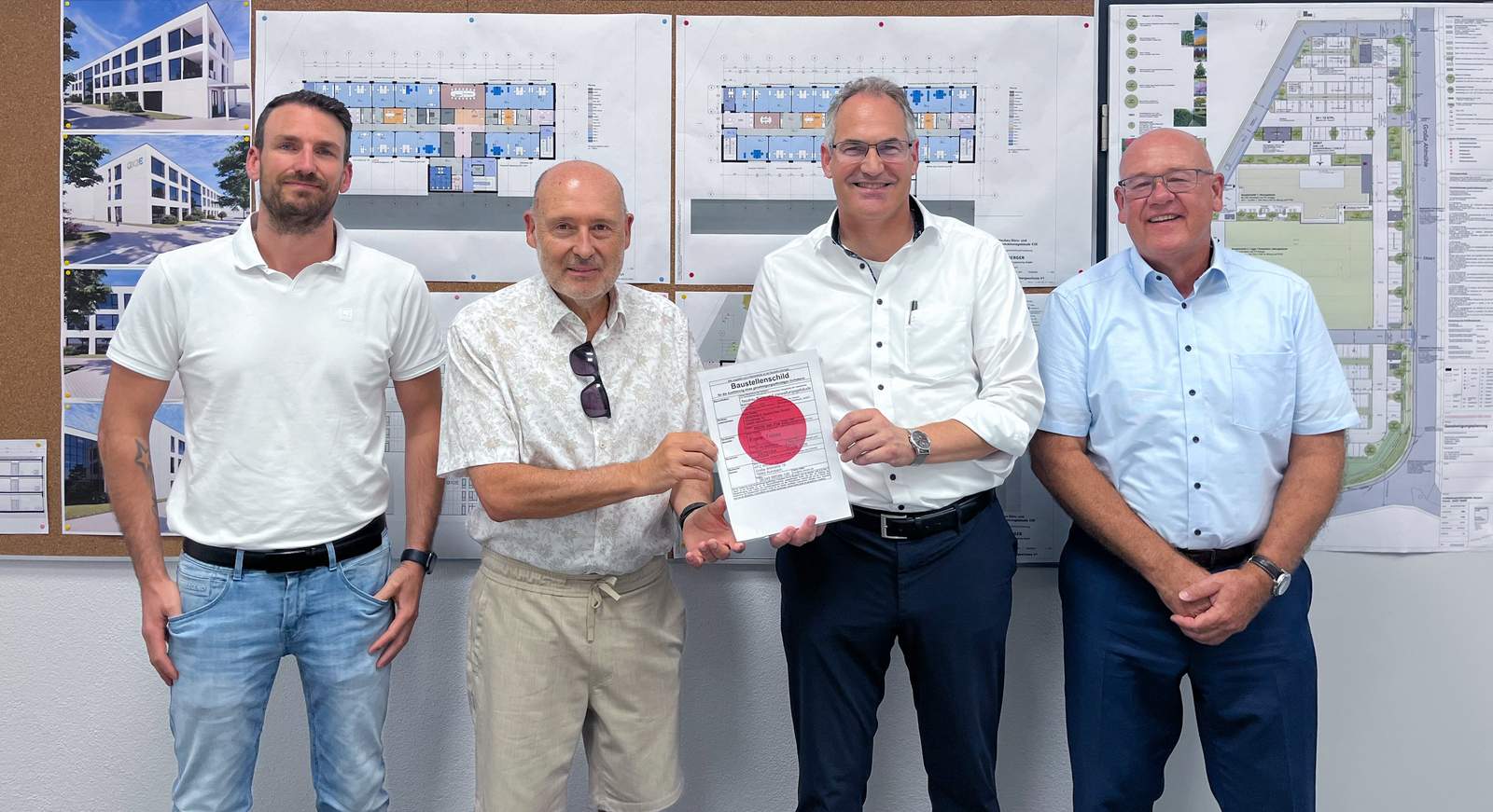 Landrat Dietmar Seefeldt (Zweiter von rechts) und SÜW-Wirtschaftsförderer Uwe König (rechts) überreichen Stefan Götz (links) und Geschäftsführer Dr. Karlheinz Weiss von der X2E GmbH den „Roten Punkt“ als offizielles Zeichen dafür, dass der Bau des neuen Firmenhauptsitzes in Rohrbach starten kann. Foto. X2E GmbH. Pressefrei.